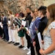 Nuoria opiskelijoita valmistumispäivänä todistukset ja kukat kädessään.